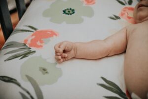 Baby Sleeping In a Crib, Baby Laying on a Flowered Bed Sheet